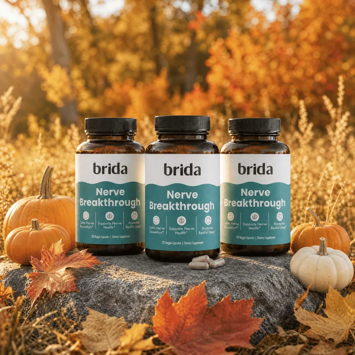 Three bottles of Brida Nerve Breakthrough on a rock with autumn pumpkins and leaves